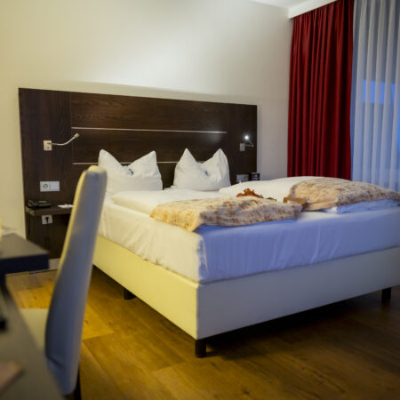 Modern eingerichtetes Doppelzimmer im Hotel Rheingarten mit großem Bett und stilvoller Dekoration