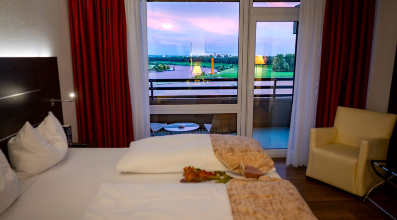 Modernes Hotelzimmer im Hotel Rheingarten in Duisburg mit Blick auf den Rhein bei Sonnenuntergang