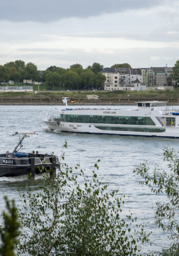 Blick auf den Rhein mit Frachtschiff und Ausflugsschiff nahe dem Hotel Rheingarten