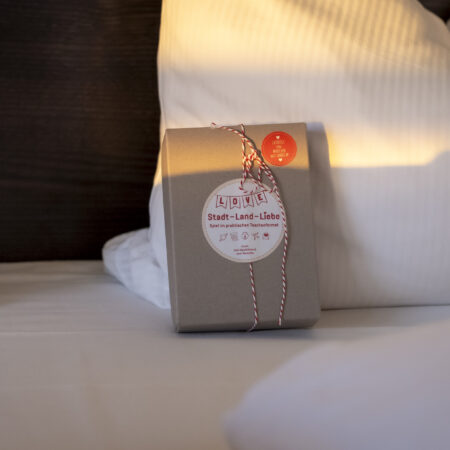 Geschenkbox Stadt-Land-Liebe im Hotel Rheingarten, liebevoll dekoriert als Aufmerksamkeit auf dem Hotelbett.