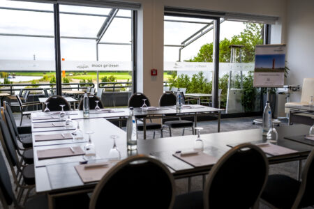 Heller Tagungs- und Konferenzraum im Hotel Rheingarten mit Blick auf die Terrasse und den Rhein, vorbereitet für eine Besprechung.