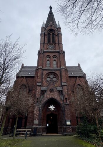 Außenansicht der ehemaligen Kirche des Kolumbarium Duisburg mit Kirchturm und Eingangsportal.