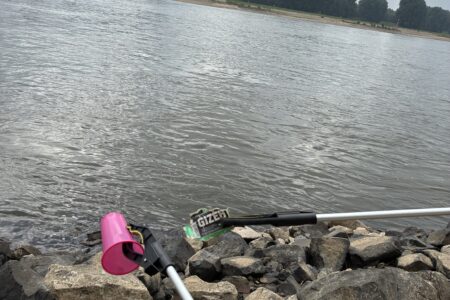 Müllsammelaktion am Rheinufer beim Rhine Clean Up 2026 mit Greifzangen und gesammeltem Abfall.